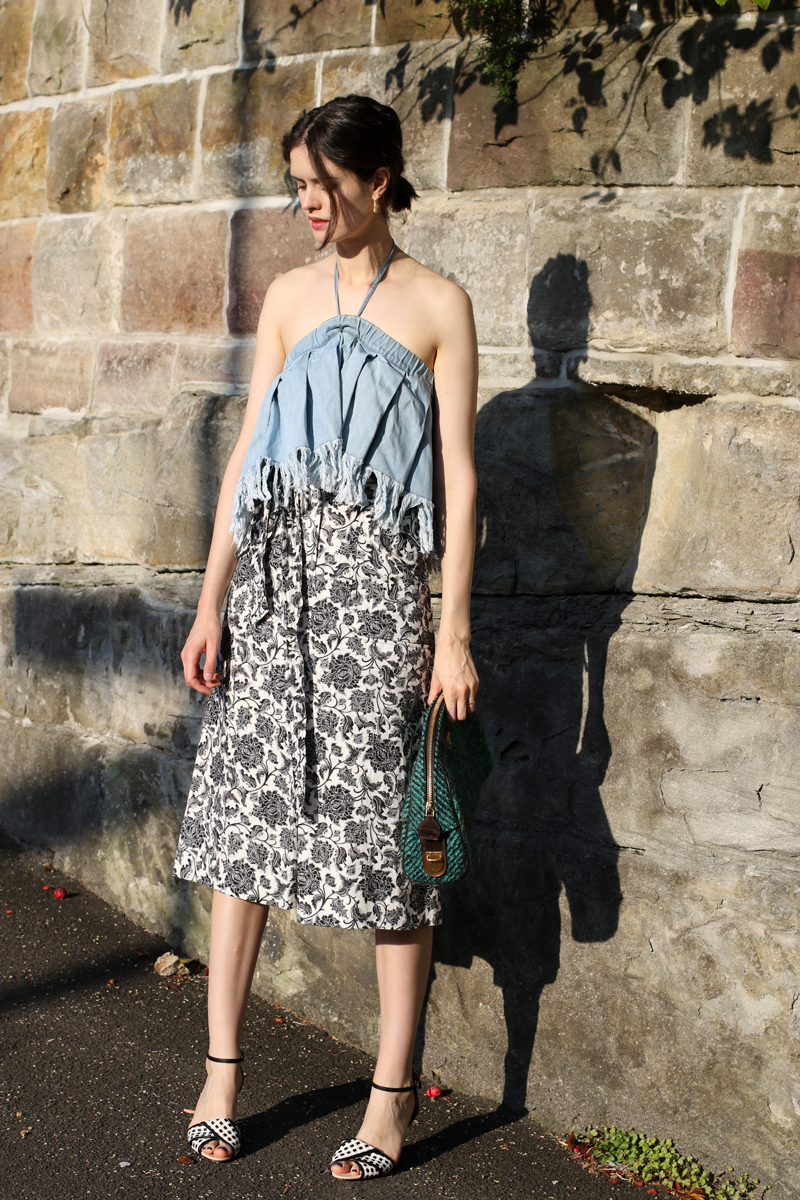 Chloe Hill Wearing Zimmermann floral midi skirt, prada clutch sportmax leather sandals and Vale denim frayed jean top on the streets of sydney