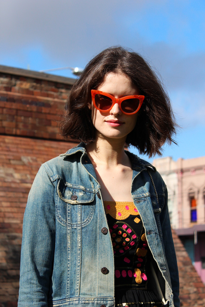 Chloe Hill Wearing Citizens of Humanity Denim Jacket, Easton Pearson beaded top and skirt, Pared eyewear orange sunglasses and Furla yellow metropolis bag